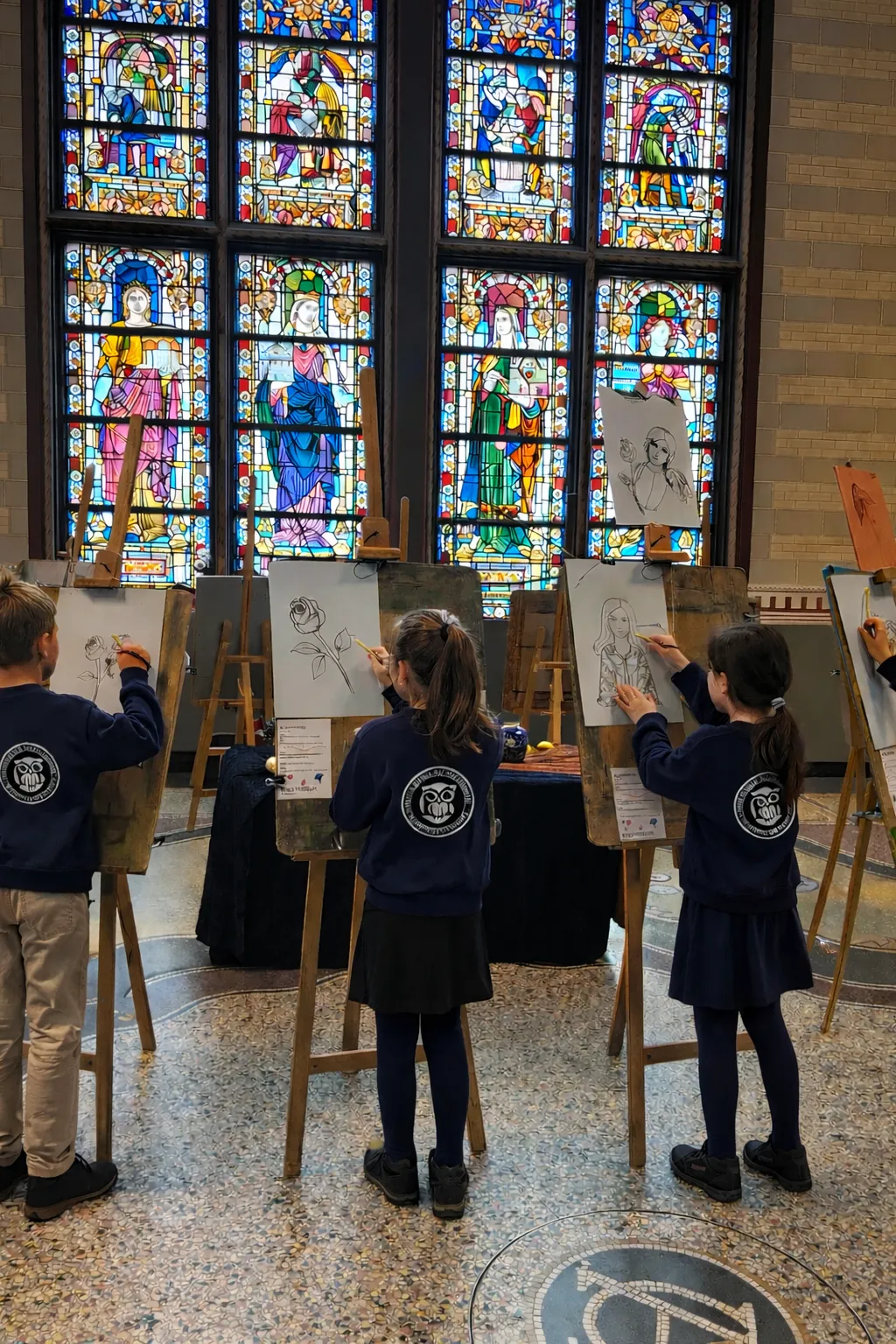 Kinderen tekenen op ezels voor een groot glas-in-loodraam